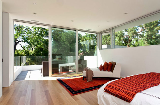 Phòng ngủ với gam màu trắng đỏ này theo phong cách tối giản. Ban công rộng với view nhìn thẳng ra vườn cây xanh mát hẳn là một sự khởi đầu mỹ mãn cho ngày mới mỗi sáng thức dậy. 